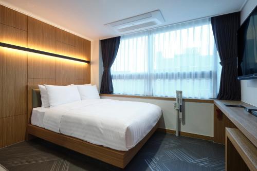 水原市S Stay Hotel的酒店客房设有床和窗户。