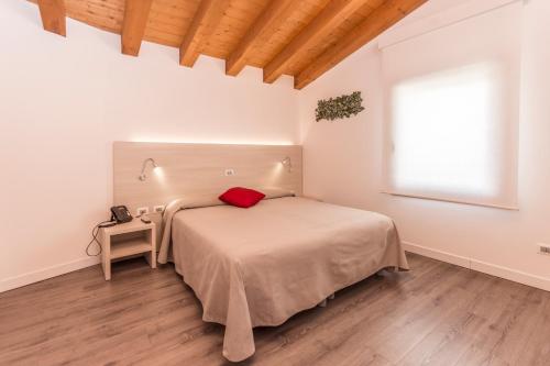 拉蒂萨纳Hotel Ristorante Cigno的一间卧室配有一张红色枕头的床