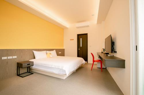 马公向日葵精致旅店民宿的一间卧室配有一张床、一张书桌和一台电视