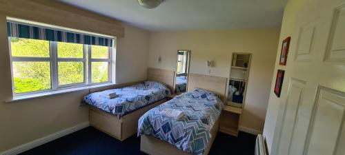 斯莱戈Yeats Village的一间卧室设有两张床和窗户。