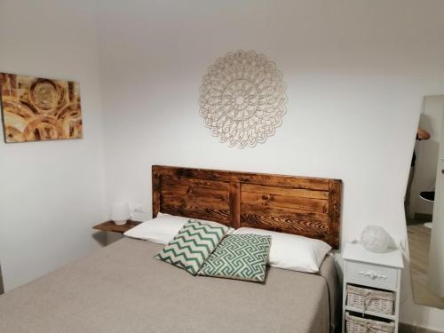 皮昂比诺Tre Orologi的一间卧室配有一张带木制床头板的床和两个枕头