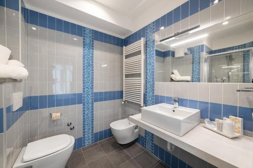 里乔内Hotel Amalfi - Smart Hotel的蓝色和白色的浴室设有卫生间和水槽