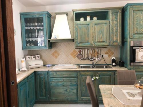 圣特雷莎加卢拉Casa Azzurra的厨房配有绿色橱柜和水槽