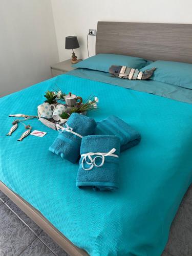 皮昂比诺APPARTAMENTI TRA CIELO E MARE的一张带蓝色毛巾和剪刀的床