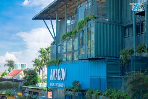 Buôn Kô SirAmacon Hotel & Coffee的蓝色的建筑,上面有标志