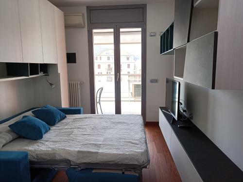 萨沃纳Appartamenti Lungomare Savona的一间卧室配有一张带蓝色枕头的床和电视。
