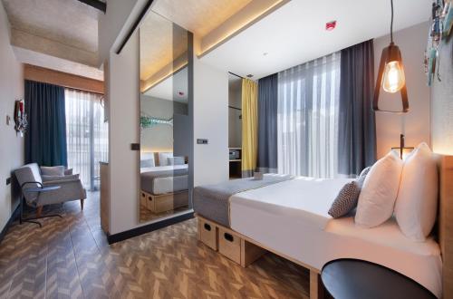 安塔利亚Trend Suites CYCLE的一间卧室配有一张大床和镜子