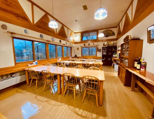 白马村ROSSI STAR的大型用餐室配有木桌和椅子