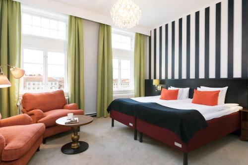 卡尔马ProfilHotels Calmar Stadshotell的一间卧室配有一张床、一张沙发和一把椅子