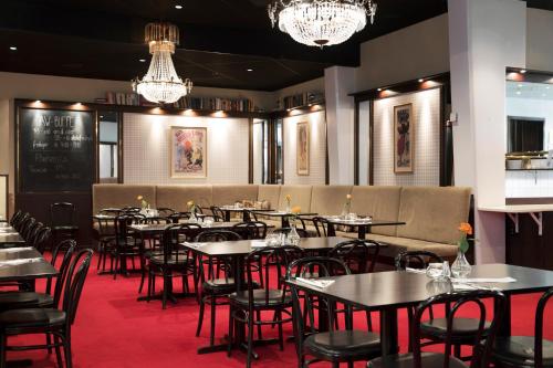 延雪平ProfilHotels Savoy的用餐室配有桌椅和吊灯。