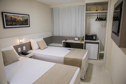 UbáTrip Hotel Ubá的酒店客房配有两张床和一张书桌