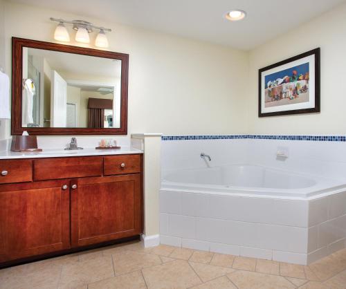 奥欣赛德Club Wyndham Oceanside Pier Resort的带浴缸、水槽和镜子的浴室