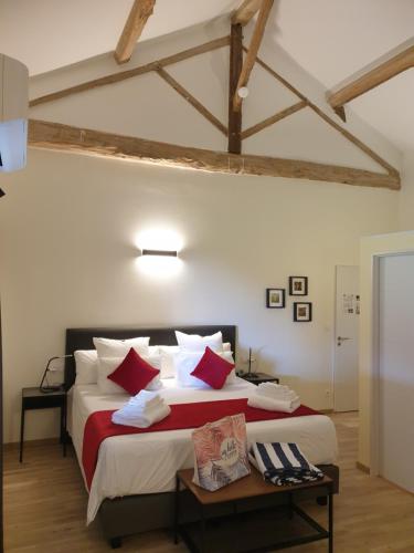 MarcollinChambres et Table d'hôtes "La Pastorale Gourmande" FR - NE - EN - DE - IT的一间卧室配有一张带红色和白色枕头的大床