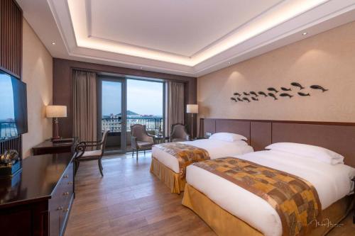 北京北京龙熙维景国际会议中心的酒店客房设有两张床和大窗户。