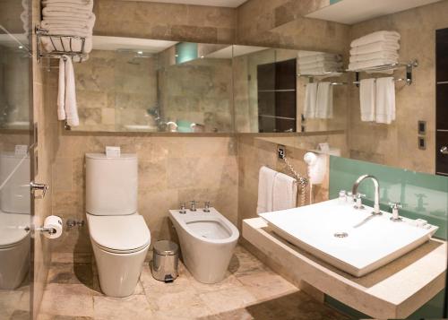 门多萨门多萨莫德酒店的浴室配有卫生间、盥洗盆和浴缸。