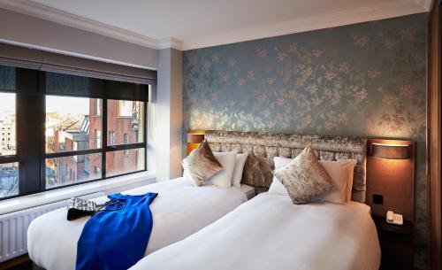 都柏林Handel's Hotel的酒店客房设有两张床和窗户。