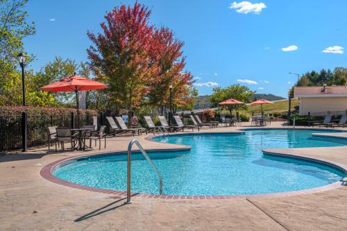 布兰森Club Wyndham Mountain Vista的一个带桌椅的游泳池以及遮阳伞