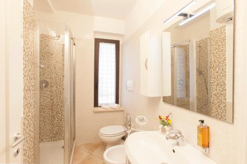奥尔贝泰洛Agriturismo Colle Oliveto的白色的浴室设有卫生间和水槽。