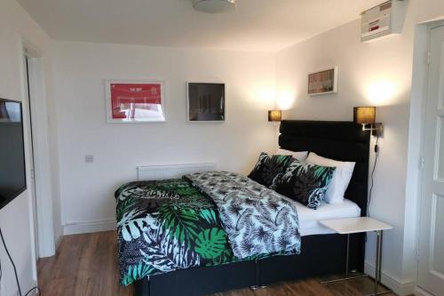 卡迪夫Stylish studio bungalow, close to Cardiff Centre的一间卧室配有一张带绿色和白色棉被的床