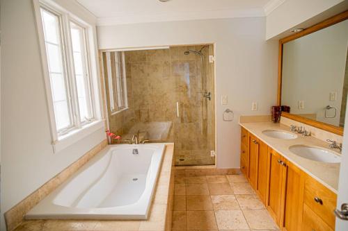 格雷斯湾Villa Renaissance Unit 205 Grace Bay Beach的带浴缸、两个盥洗盆和淋浴的浴室。