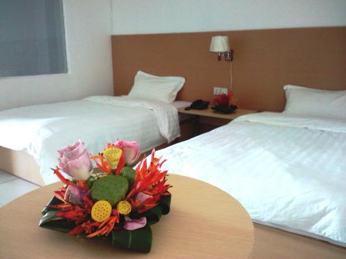 维拉港航空商务酒店 的酒店客房,设有两张床和一张鲜花桌。