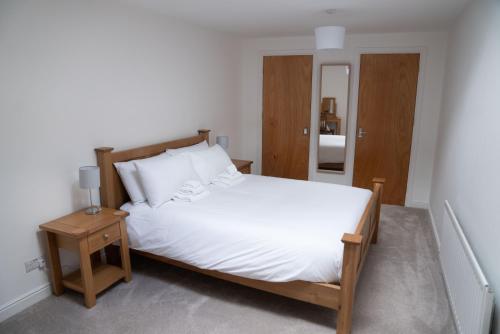 凯西克Low Haven的卧室配有一张白色的大床和一张桌子