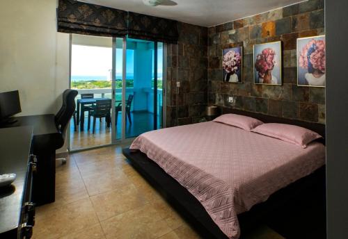 普拉亚布兰卡BlueLagoon Apartamento en Playa Blanča的一间带一张床和一张书桌的卧室以及一个阳台