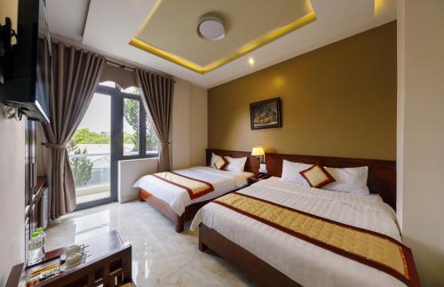 大叻Bonjour Da Lat Hotel的酒店客房设有两张床和电视。