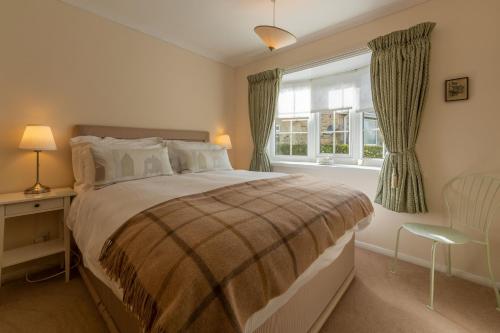 米德尔赫姆Fox Cottage的一间卧室设有一张大床和一个窗户。