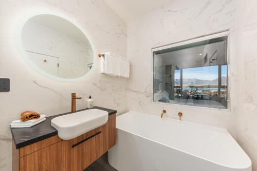 特卡波湖Galaxy Boutique Hotel的带浴缸、水槽和镜子的浴室
