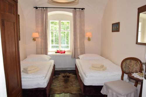 多克西Hájovna hradu Houska的带窗户的客房内的两张床