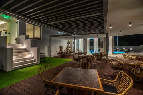 雅典Glyfada Riviera Hotel的木制甲板上配有桌椅的庭院