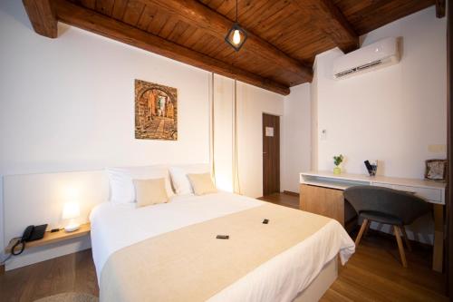 乌马格Hotel Natura Vilanija的卧室配有一张白色大床和一张书桌