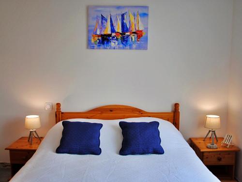 La JonchèreMaison de vacances à 10min des plages et de la Tranche sur Mer的一间卧室配有一张带两个蓝色枕头的床