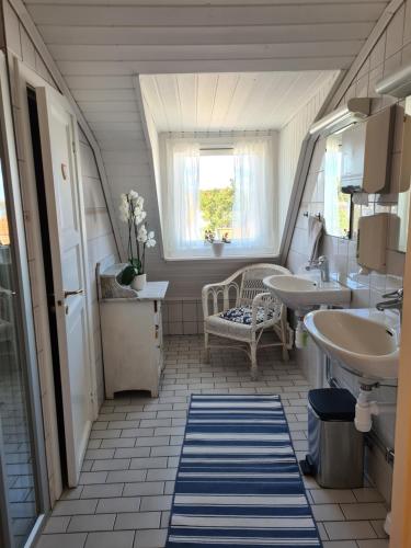 桑德港Missionshuset Bed & Breakfast的一间带两个盥洗盆和窗户的浴室