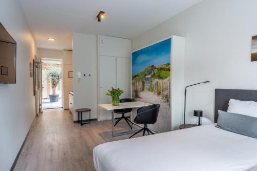 弗利辛恩Hotel Residentie Vlissingen的酒店客房配有一张床铺和一张桌子。