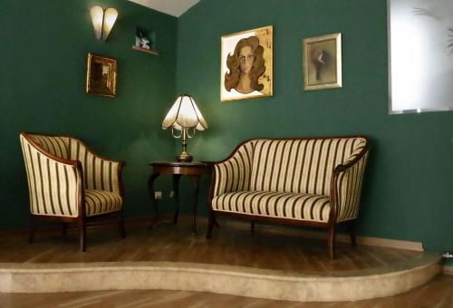 斯普利特Luxury Suite Jasmin的绿墙客房内的2把椅子和桌子