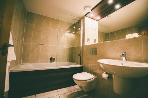 威廉堡尼维斯河畔旅馆的浴室配有盥洗盆、卫生间和浴缸。