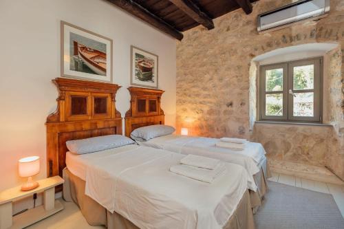 科托尔18th Century Villa in the UNESCO Bay of Kotor的一间卧室设有两张床和窗户。