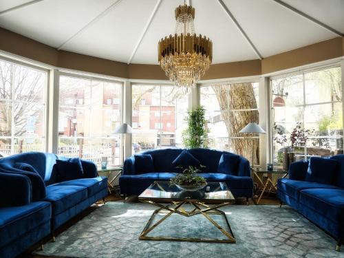 韦斯特罗斯阿卡德酒店的客厅配有蓝色的沙发和吊灯。