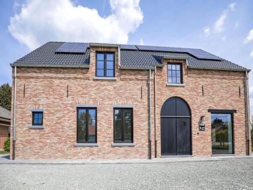 龙塞Beautiful house in Flemish Ardennes for cyclists的屋顶上太阳能板砖屋的图象