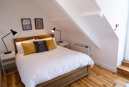 丁格尔Apartments in Dingle Town Center的一间卧室配有带白色床单和黄色枕头的床。