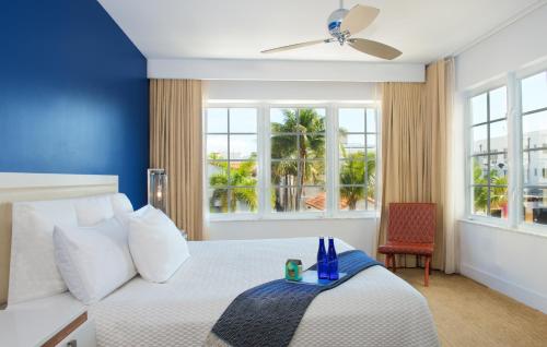 迈阿密海滩Blue Moon Hotel的卧室配有白色床和蓝色墙壁
