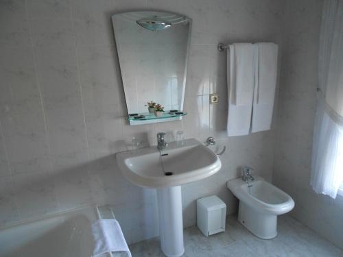 比利亚隆加Habitaciones Ninfa的白色的浴室设有水槽和卫生间。
