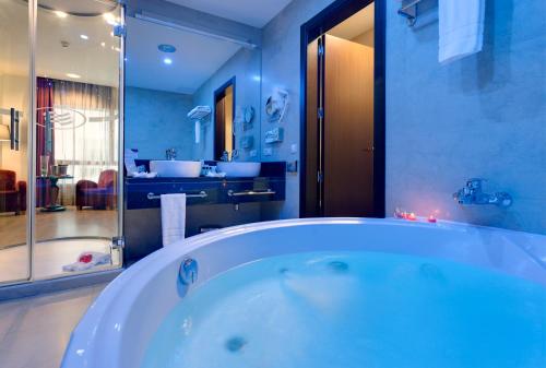 马德里Hotel Crowne Plaza Madrid Airport的大型浴室设有浴缸和淋浴。
