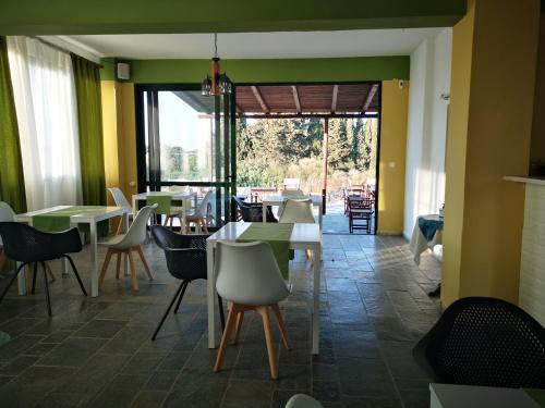 马斯蒂查里伊利奥斯和艾琳公寓式酒店的餐厅设有桌椅和大窗户。