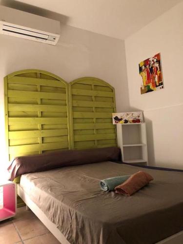巴斯蒂亚U riposu的一间卧室配有一张大床和绿色床头板