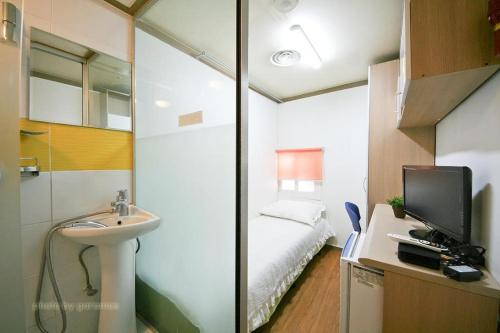 首尔Rodemhouse的一间带水槽的浴室和一间带一张床的卧室