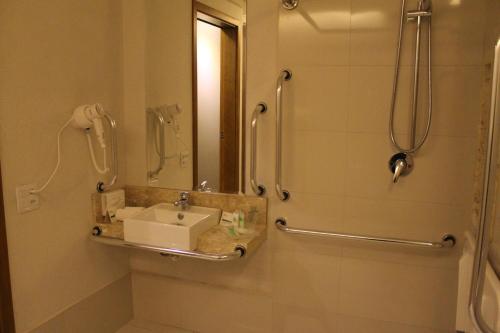戈亚尼亚Holiday Inn - Goiania, an IHG Hotel的浴室配有盥洗盆和带镜子的淋浴