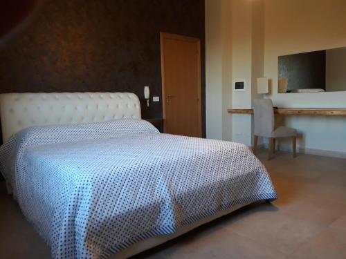 加利波利Terra e colori的一间卧室配有一张带蓝白色毯子的床